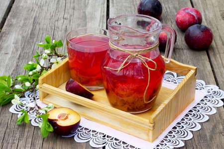 Stewed plums in a jar on a wooden background