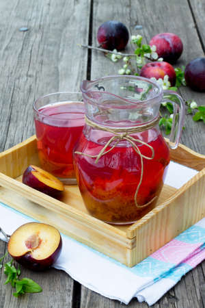 Stewed plums in a jar on a wooden backgroundの写真素材