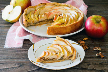 Apple tart, shortcrust pastry pie with walnuts on a wooden backgroundの写真素材