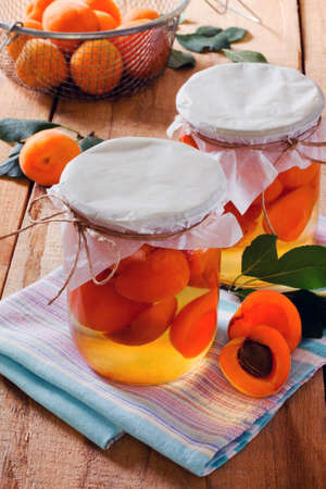Apricots canned in sweet syrup, the bank on a wooden tableの写真素材