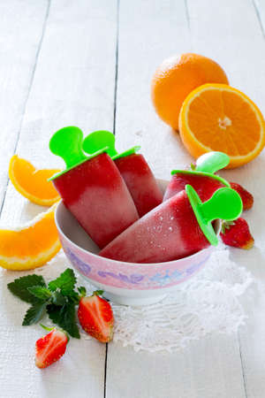 Strawberry ice cream pop ice orange on a white tableの写真素材