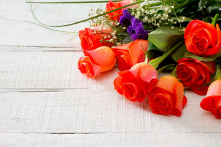 Pink rose flowers on white wooden background