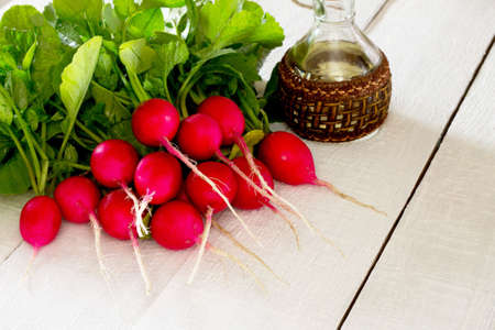 A bunch of radishes on a white wooden tableの写真素材
