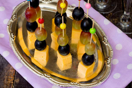 Canape with cheese and grapes on a wooden tableの写真素材
