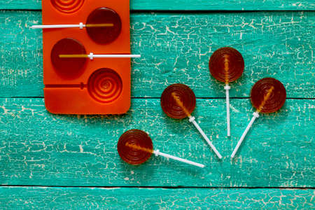 Candy lollipop on a stick the ball on a wooden backgroundの写真素材