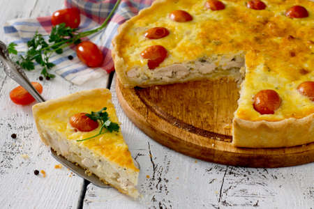 Open pie quiche Lauren with a chicken on a white wooden table