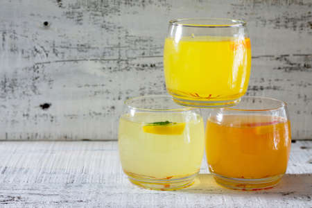 Fresh citrus juices on a white wooden tableの写真素材