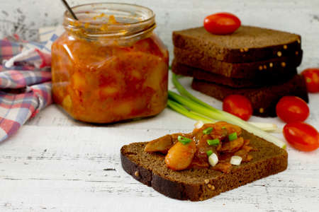 Home caviar of tomatoes and beans, spread on bread, in a rustic style.の写真素材