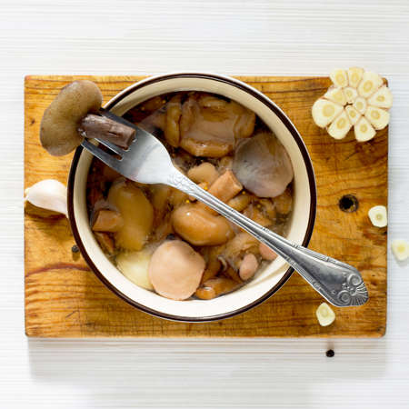 Marinated mushrooms in a ceramic bowl, top view, selective focus.の写真素材
