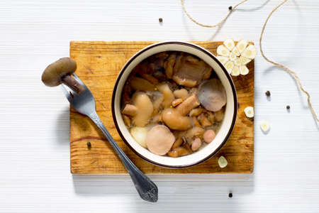 Marinated mushrooms in a ceramic bowl, top view, selective focus.の写真素材