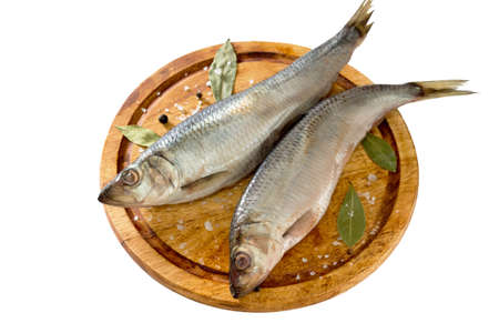 salted herring with pepper and bay leaf on wooden boardの写真素材