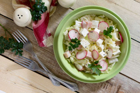 Salad with fresh radish, cabbage, feta cheese and chicken in a rustic styleの写真素材