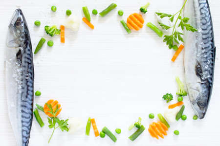 Fresh tasty vegetables and raw fish for cooking on a wooden background. Diet or vegetarian food concept.の写真素材