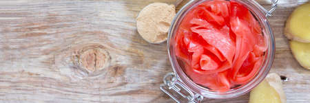 Ginger root and slices of pickled ginger on a wooden table, top view.の写真素材