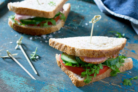Club sandwich with fresh cucumber, tomato and ham, watercress salad.
