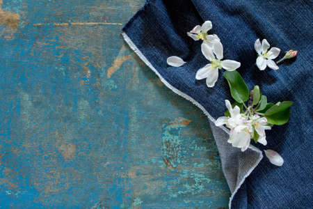 Apple tree flowers on a wooden table, top view. Space for your text.の写真素材