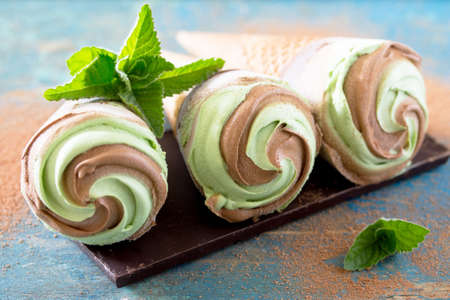 Delicious ice cream with mint and chocolate on a vintage wooden background, selective focus.の写真素材