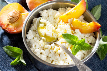 Homemade cheese, honey and fresh peaches, healthy food, cooking healthy breakfast.