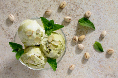 Delicious ice cream pistachio and almond petals on a brown stone background, selective focus.の写真素材