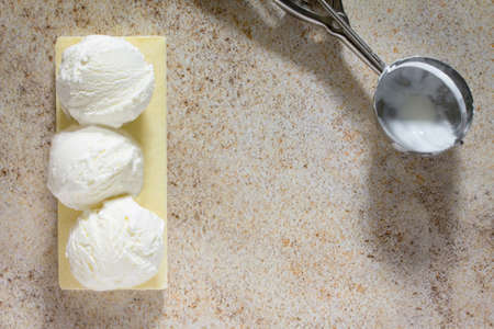 Ice cream with vanilla in a form a ball, place for your text.の写真素材