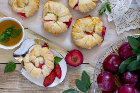 Flaky pastry with berry filling, biscuit malt and mint tea on a table in a rustic style. Top view .の写真素材