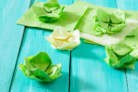 Crafts, paper flower water lily. Copy space. Paper napkins and water lily on a wooden table....