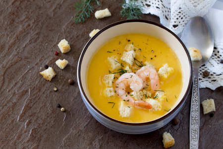 Mashed vegetable soup and shrimp with garlic and green dill on a stone background with rusk. Diet, vegetarian food.の写真素材