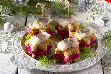 Canapes in the form of a star with pickled herring, beetroot and dill dip. Breakfast table at Christmas or New Year.の写真素材