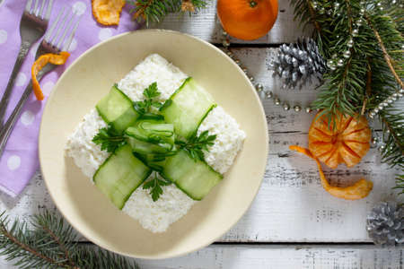 Salad with meat and mushrooms, cucumber decoration bow on a Christmas table.の写真素材