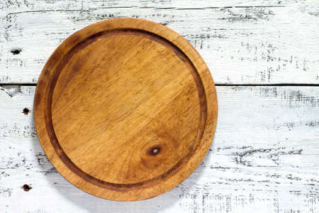 Wooden board on white wooden table. Copy space.の写真素材