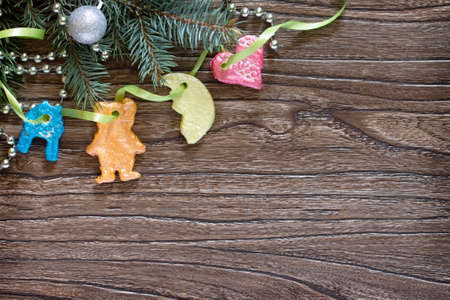 Christmas frame. Christmas tree branches and Christmas toys made of of salt dough on wooden background with copy space.の写真素材