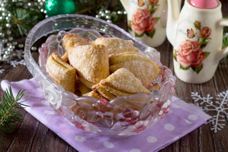 Cookies from puff pastry and sugar sprinkles on a festive Christmas dinner or New Year.