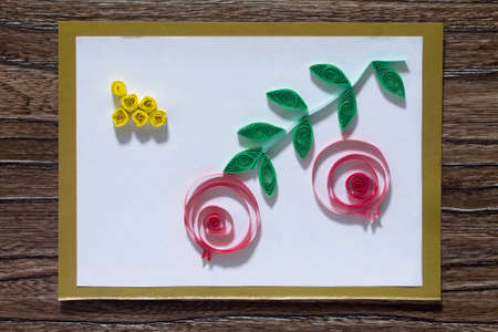 The child create greeting cards origami paper honey and garnet tree branch on a wooden table. Of the Jewish New Year celebration, Rosh Hashana and Tu B'Shvat.の写真素材