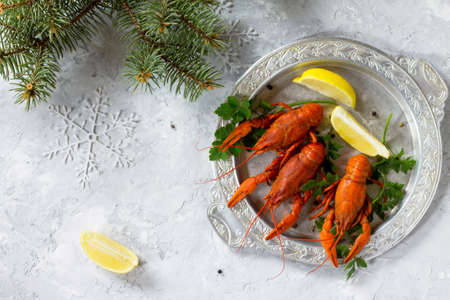 Boiled crawfish, lemon and parsley on a concrete background. Appetizer for Christmas or New Year's table. Food background. The concept of healthy eating.の写真素材