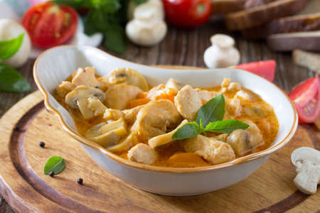 Traditional hot ragout with meat and mushrooms (chicken, mushrooms, carrots, tomatoes). Beef stew. Healthy food concept.の写真素材