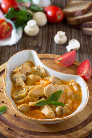 Traditional hot ragout with meat and mushrooms (chicken, mushrooms, carrots, tomatoes). Beef stew. Healthy food concept.の写真素材