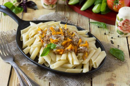 Pasta with minced meat in a frying pan on a table in a rustic style.の写真素材