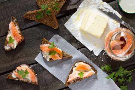 Salted salmon fillets with sea salt on rye bread. Fresh fish. Top view, copy space. Food background.の写真素材
