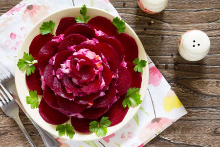 Festive decorated salad of beets, an appetizer in the form of roses on wooden table.の写真素材