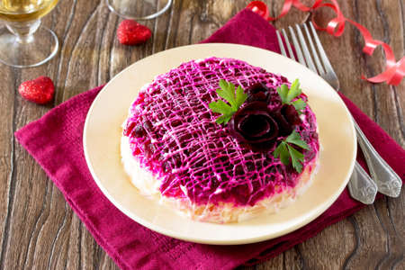 Festive salad herring under a fur coat (from beetroot, eggs, herring, potatoes, cheese, carrots) on the old wooden background.の写真素材