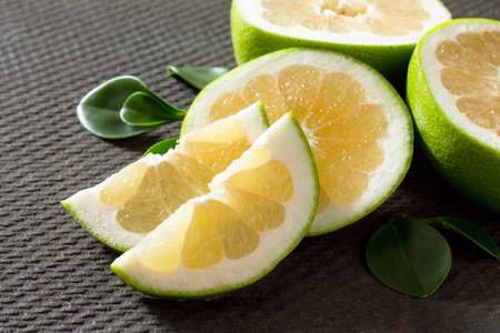 Grapefruit sweetie on a concrete gray background. The concept of healthy nutrition and diet.の写真素材