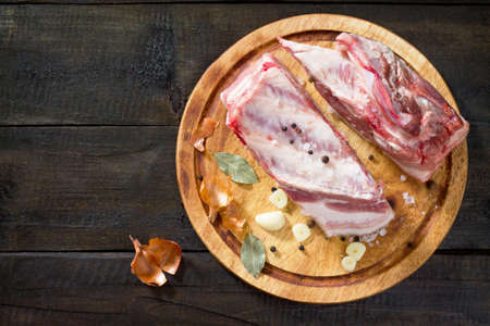 Salty lard with spices and parsley on a wooden background. Top view, copy space.の写真素材