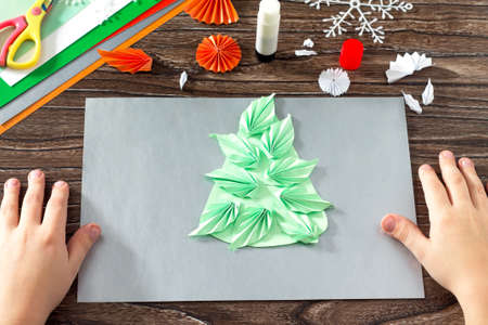 The child makes a paper Christmas tree, snow, fox and hare. Creating paper detail Christmas tree....