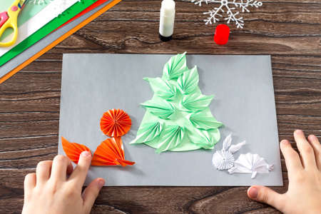 The child makes a paper Christmas tree, snow, fox and hare. Creating details Show. Children's art...