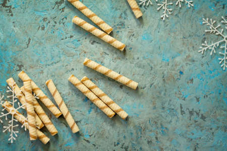 Christmas frame. Tubules waffles with cream and chocolate on a gray stone background. Copy space. Top view.の写真素材