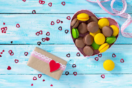 Background Valentine's Day. Valentine's Day or birthday gifts makarons cake with heart on a blue wooden table. Top view.の写真素材