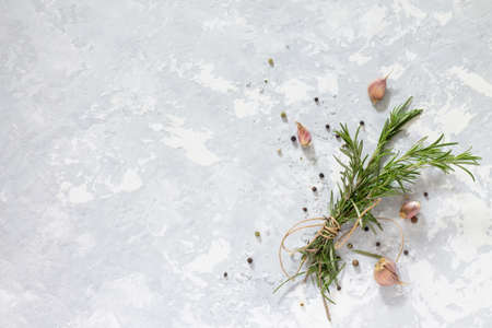 Sprigs of rosemary tied with string and garlic on a gray stone background. Copy space.の写真素材