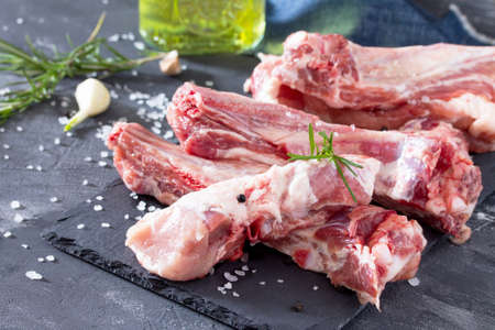 Raw meat on the bone with olive oil, fresh herbs and spices. Healthy food concept.の写真素材