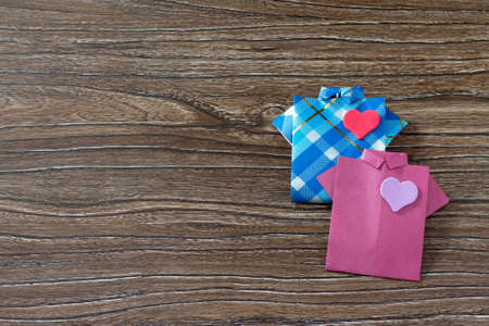 Gift for Father's Day. The child makes a gift of origami paper shirt. Made by hand. Children's art project, a craft for children.の写真素材