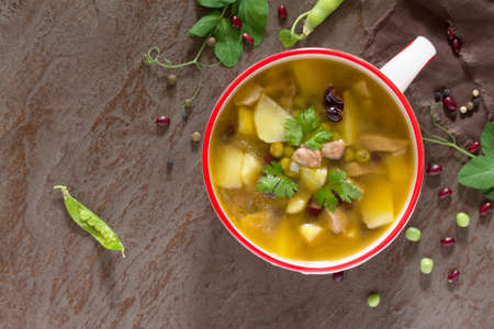 Soup with meat, beans, green peas and fresh vegetables on a concrete background. The concept of a healthy and proper nutrition. Copy space.の写真素材